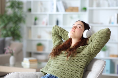 Young woman wearing headphone relaxing listening music at home